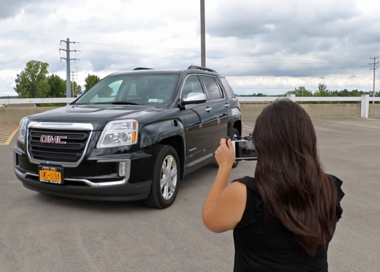 Woman taking a photo of a car.