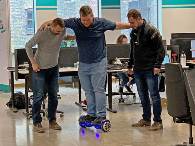 Team members trying a hover board.